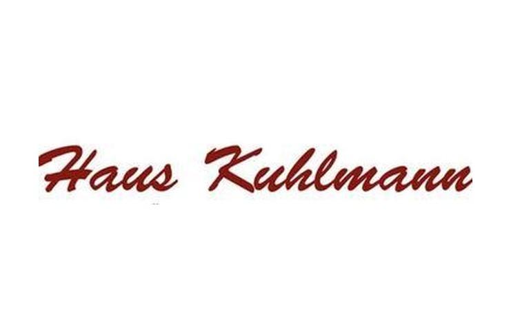 Rotes, geschwungenes Schriftzug-Logo mit den Worten „Haus Kuhlmann“ auf weißem Hintergrund.